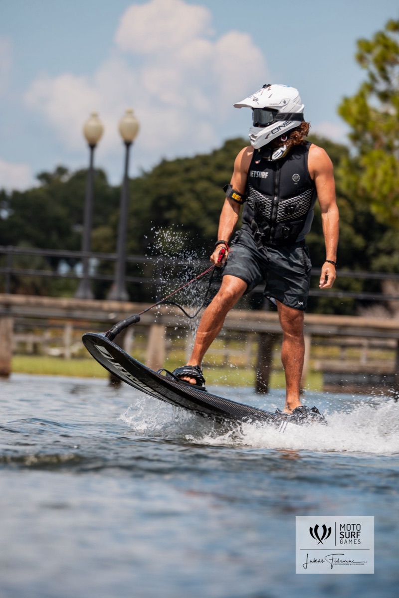 Rider standing tall on a jetsurf board past the marina